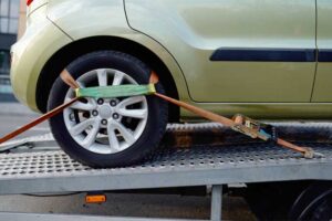 Car strapped to a trailer for transportation