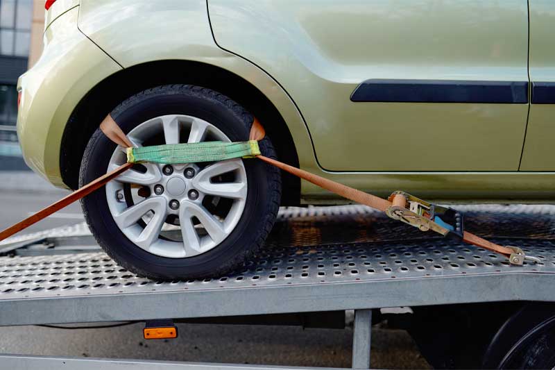 Car strapped to a trailer for transportation